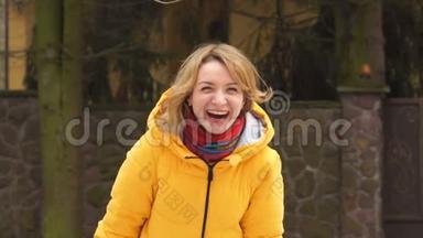 一个30-40岁的美女真诚地笑。 她穿着一件亮黄色的夹克和一条红领巾